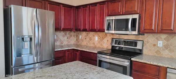 a kitchen with granite countertop wooden cabinets and stainless steel appliances