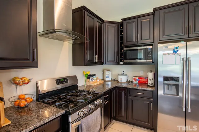 a kitchen with stainless steel appliances granite countertop a refrigerator stove and sink
