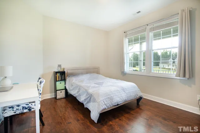 a bed sitting in a bedroom next to a window