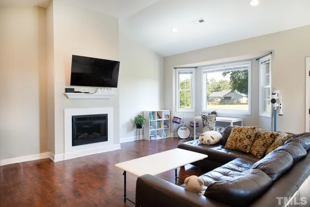 a living room with furniture a fireplace and a flat screen tv