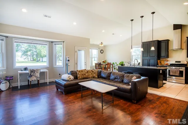 a living room with furniture kitchen view and a large window