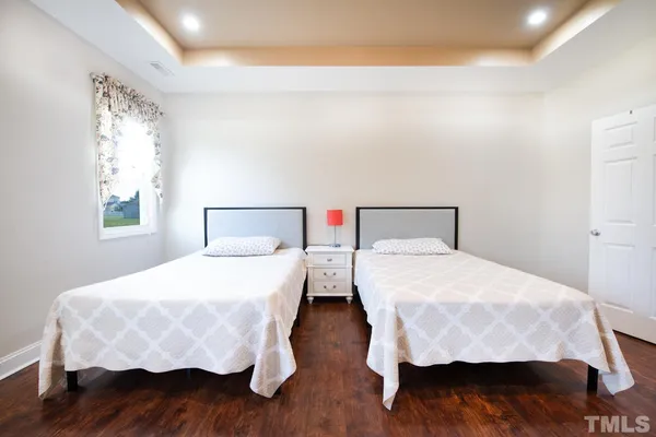 a bedroom with two beds and a wooden floor