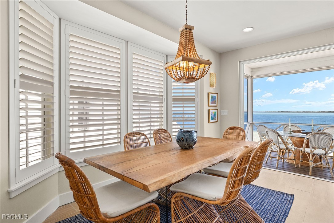 114 Useppa Island, Unit A Bokeelia, FL 33922 - Photo 11 of 44 a view of a dining room and livingroom with furniture wooden floor a chandelier