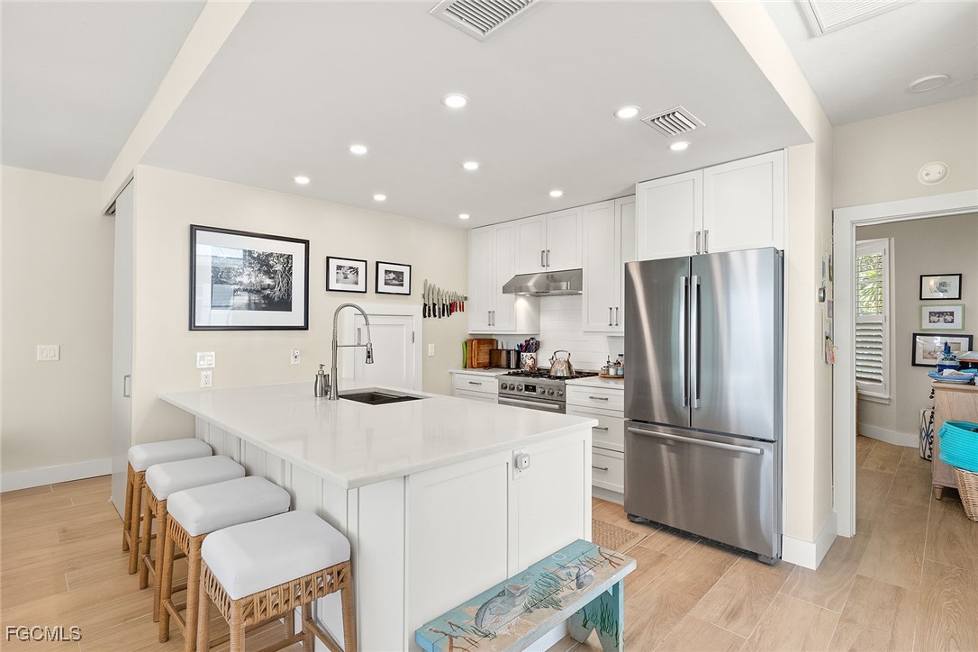 114 Useppa Island, Unit A Bokeelia, FL 33922 - Photo 13 of 44 a kitchen with stainless steel appliances a refrigerator and a refrigerator