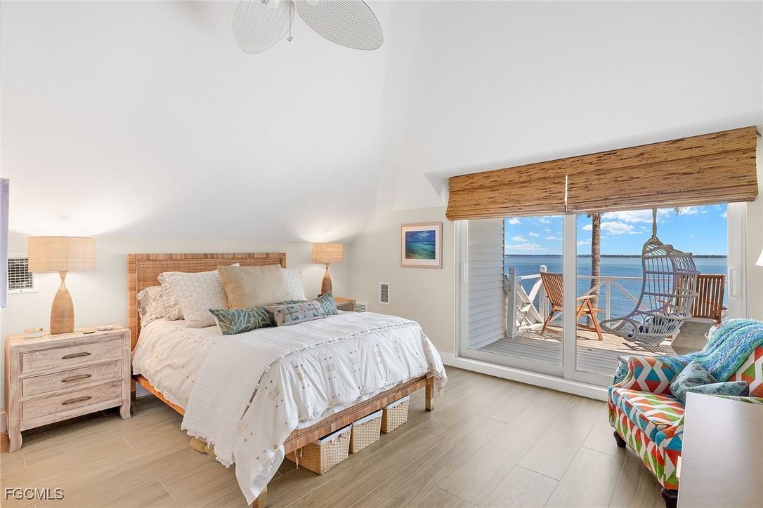 114 Useppa Island, Unit A Bokeelia, FL 33922 - Photo 18 of 44 a bedroom with a bed and a large window