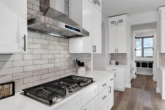 a kitchen with white cabinets and appliances