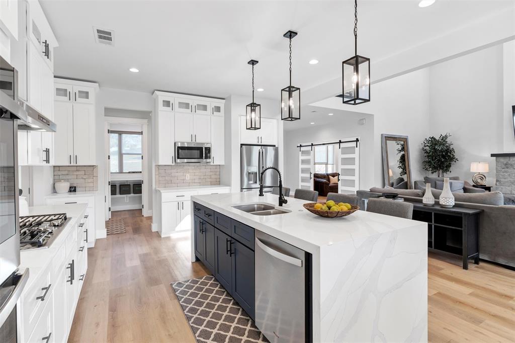175 Bittersweet Trail Weatherford, TX 76088 - Photo 14 of 40 a kitchen with stainless steel appliances granite countertop a sink a stove and a wooden floor