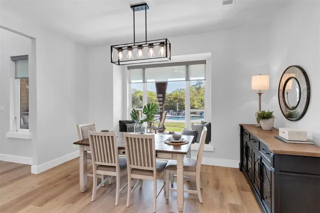 a dining room with furniture a chandelier and wooden floor