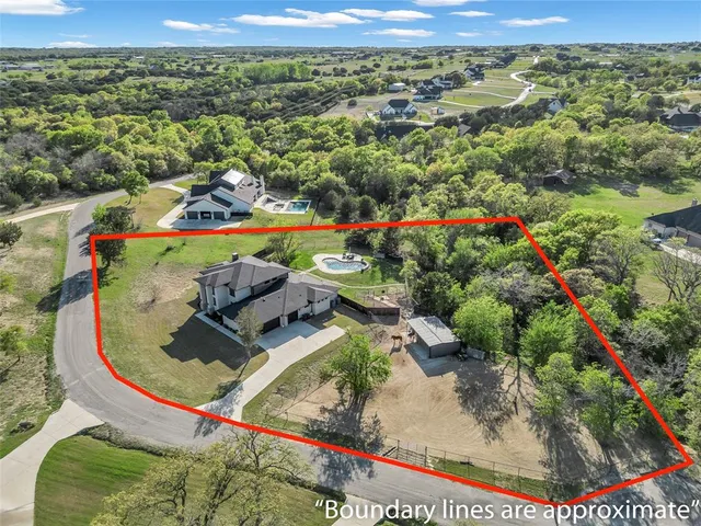 an aerial view of a house with a yard and lake view
