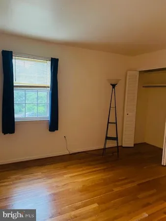 a view of a room with wooden floor and a window
