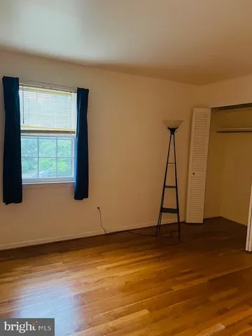 a view of a room with wooden floor and a window