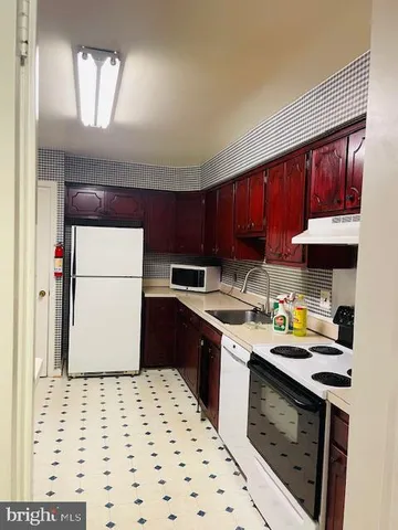 a bedroom with a bed and a refrigerator