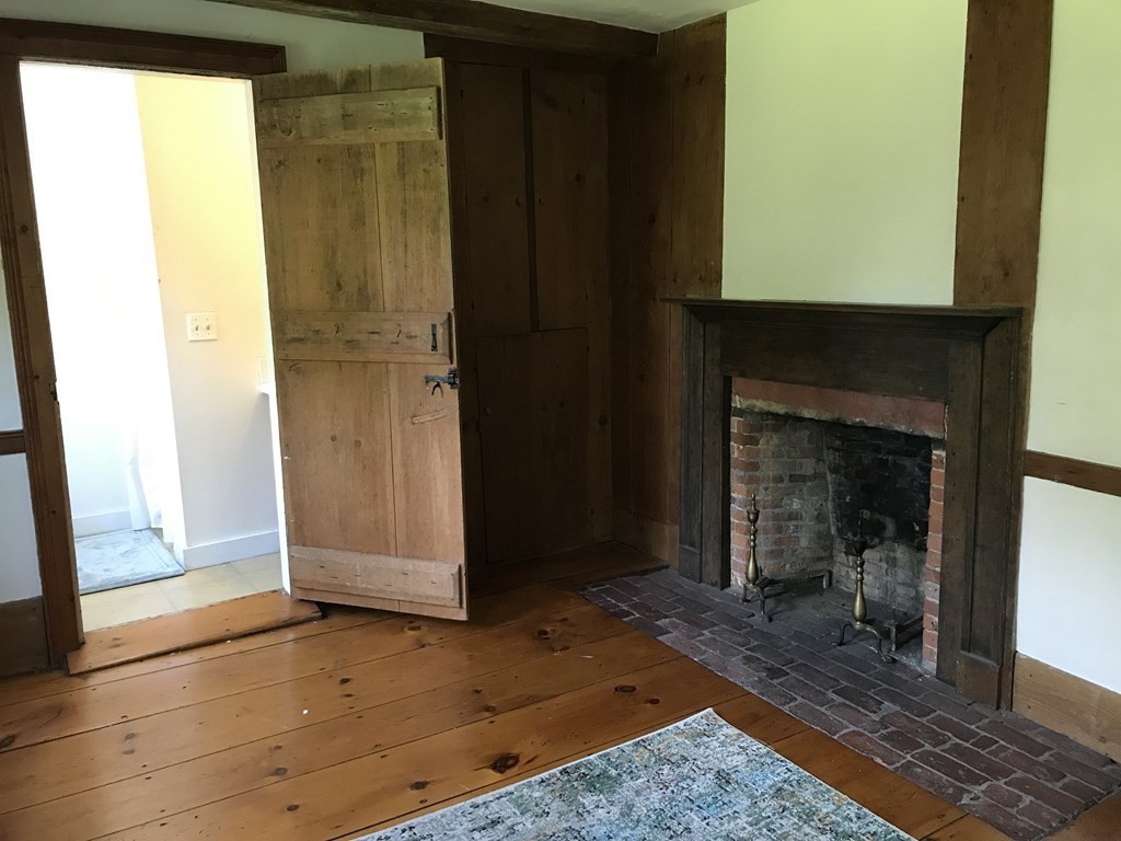 290 Amherst Road Pelham, MA 01002 - Photo 22 of 39 a view of a hallway with wooden floor and a fireplace