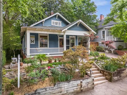a front view of a house with a yard and potted plants