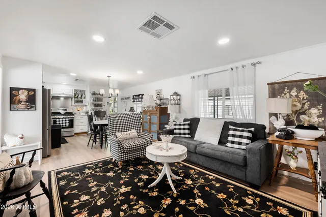 a living room with furniture and a dining table with kitchen view