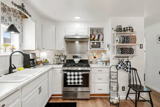 a kitchen with stainless steel appliances a stove a sink and cabinets