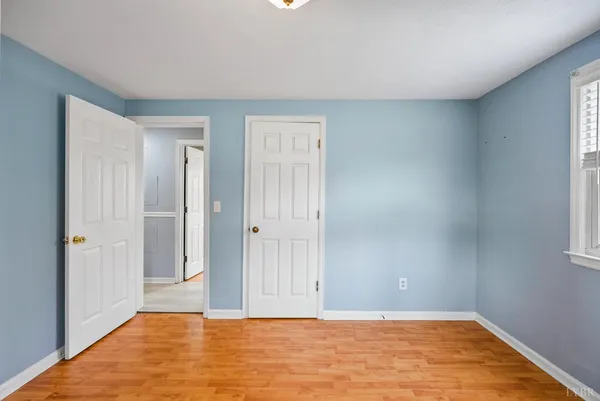 a view of a house with a large tree and wooden fence