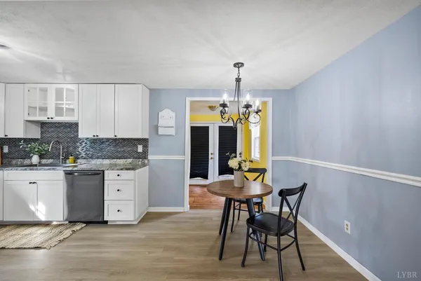a kitchen with granite countertop white cabinets and stainless steel appliances