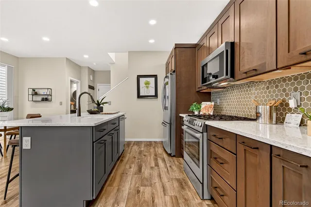 a kitchen with stainless steel appliances granite countertop a sink stove and cabinets