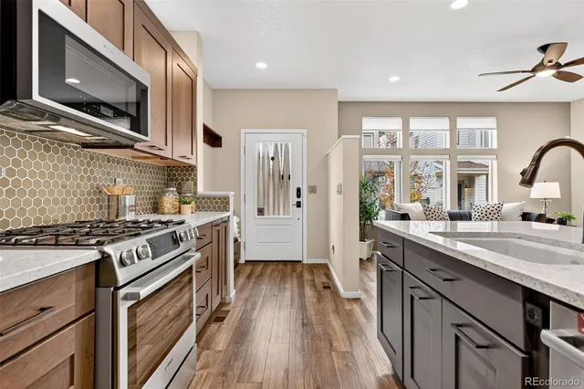a kitchen with stainless steel appliances granite countertop hardwood floor sink stove and refrigerator
