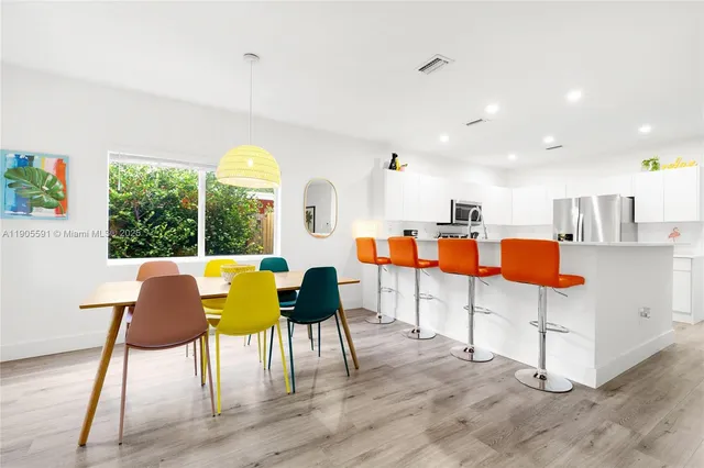 a living room with furniture and kitchen view with wooden floor
