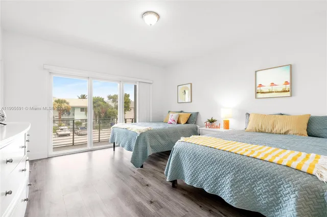 a bedroom with two large bed and a large window