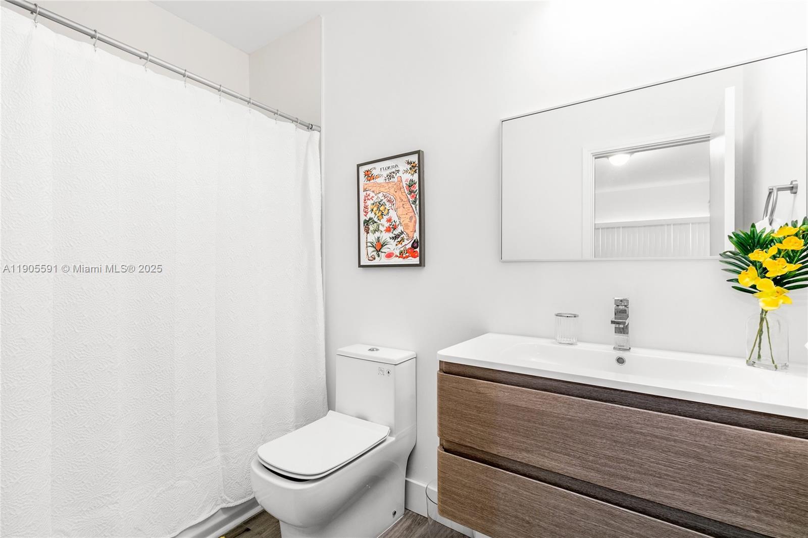 1123 Northeast 23rd Terrace Pompano Beach, FL 33062 - Photo 23 of 35 a bathroom with a sink a toilet and a mirror