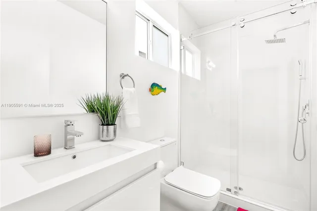 a bathroom with a granite countertop sink a toilet and shower