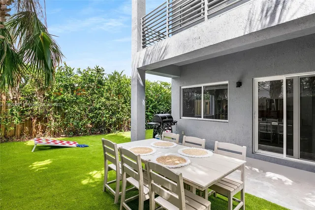 a view of a patio with table and chairs potted plants and palm trees