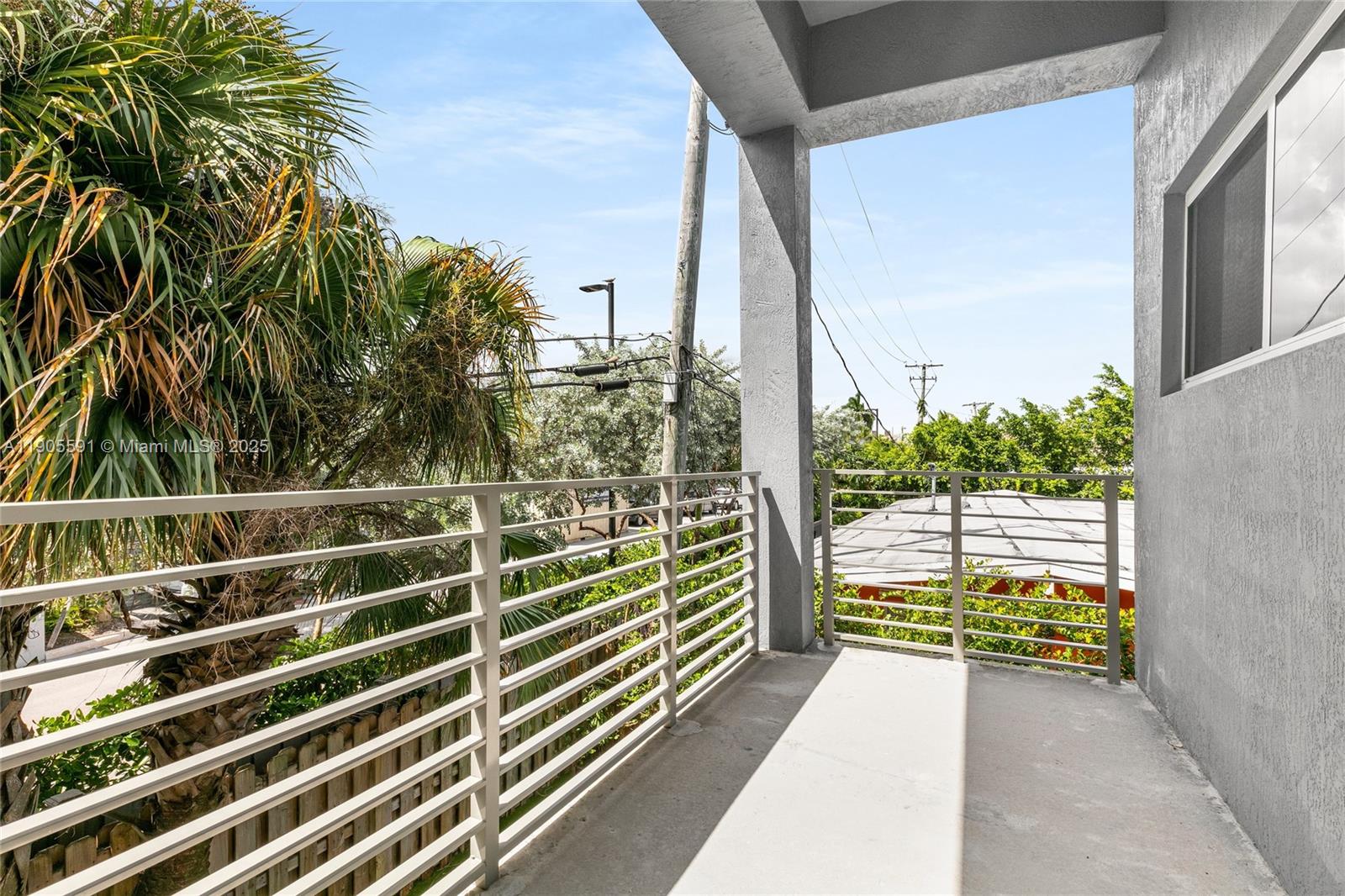 1123 Northeast 23rd Terrace Pompano Beach, FL 33062 - Photo 34 of 35 a view of a balcony with floor to ceiling windows and wooden fence