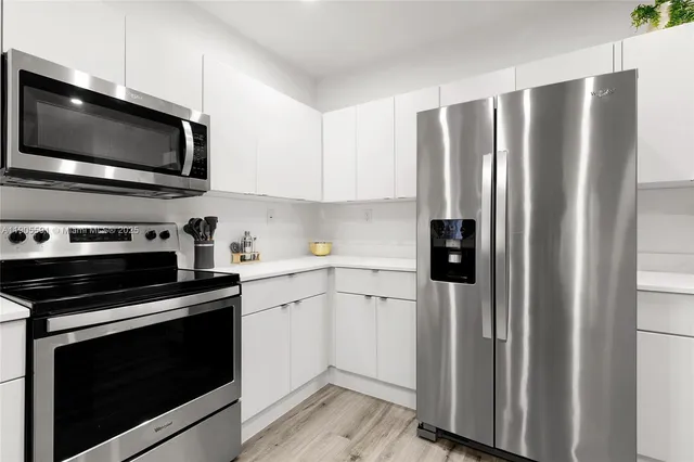 a kitchen with stainless steel appliances a refrigerator stove and microwave