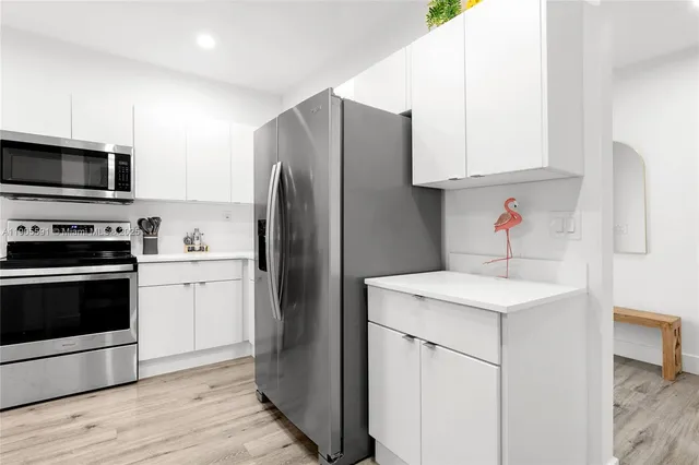 a kitchen with appliances a sink and a refrigerator