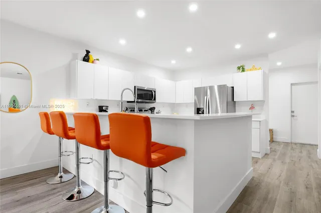 a kitchen with stainless steel appliances kitchen island granite countertop wooden cabinets and sink