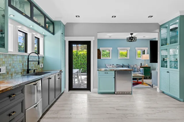 a kitchen with stainless steel appliances granite countertop a stove a sink and a wooden floors