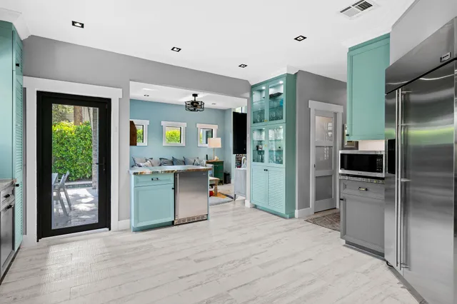 a kitchen with stainless steel appliances kitchen island granite countertop a refrigerator and a sink