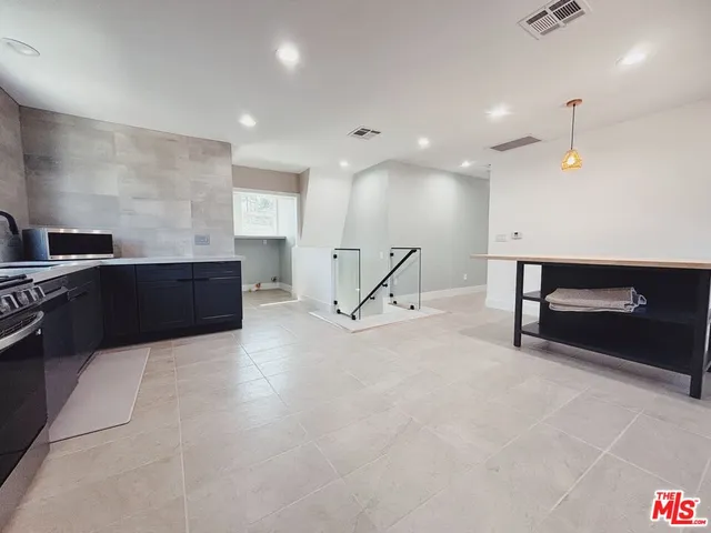 a view of kitchen with kitchen island microwave and wooden floor