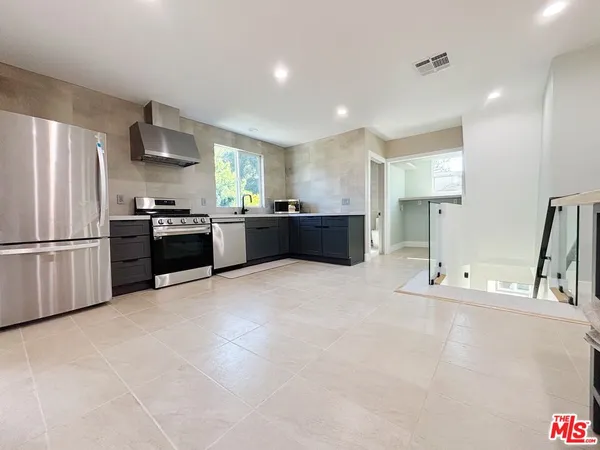 a large kitchen with stainless steel appliances lots of counter space and a refrigerator