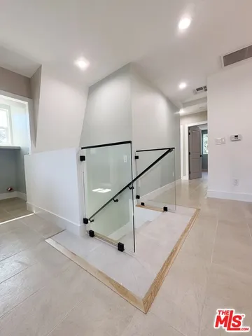 a view of a hallway with a ceiling fan