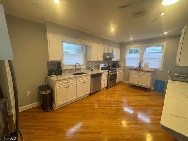 a kitchen with stainless steel appliances granite countertop a stove a sink and a refrigerator