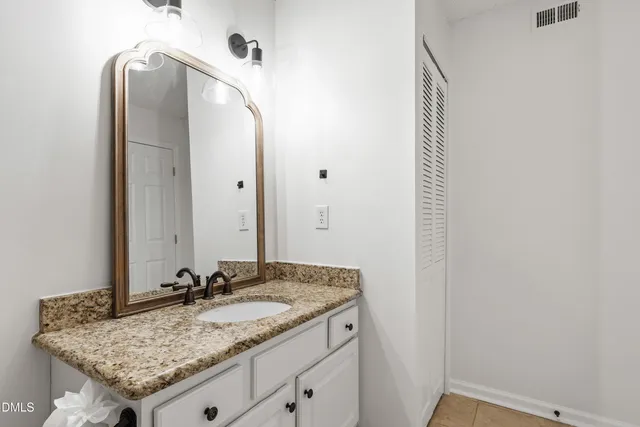 a bathroom with a granite countertop sink and a mirror