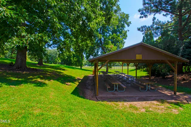 a view of a yard with table and chairs under an umbrella