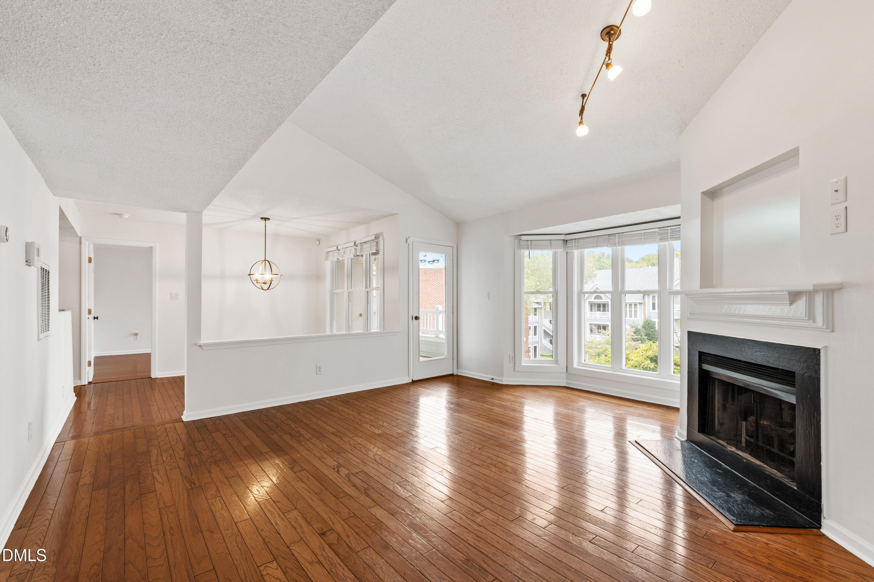 911 Washington Street, Unit 301 Raleigh, NC 27605 - Photo 3 of 22 a view of an empty room with wooden floor and a fireplace