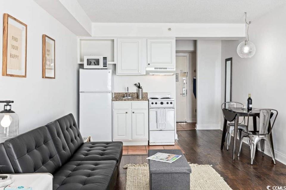 1207 South Ocean Boulevard, Unit 21001 Myrtle Beach, SC 29577 - Photo 11 of 23 Living area featuring dark wood-type flooring and a textured ceiling