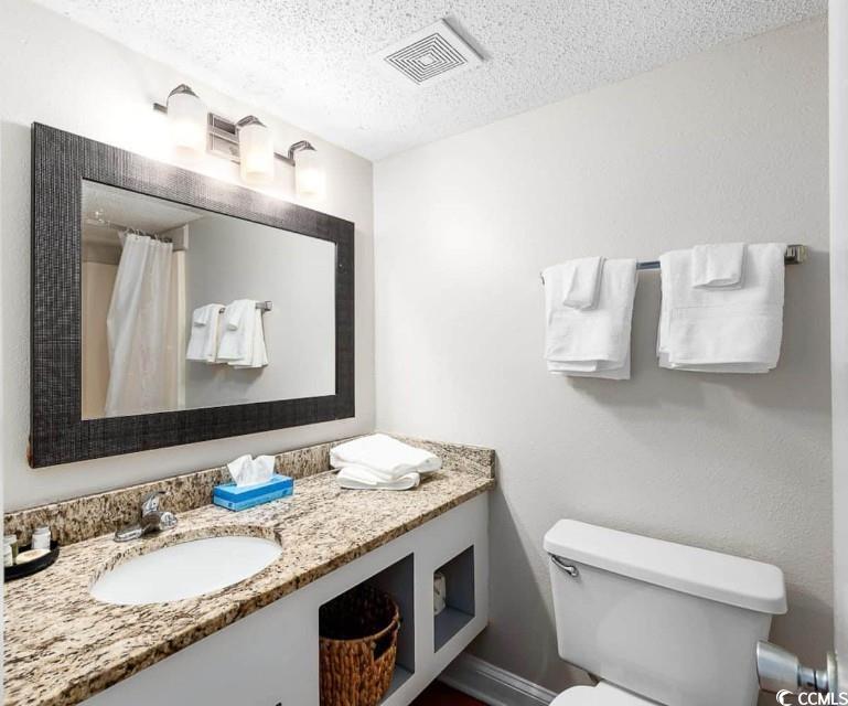 1207 South Ocean Boulevard, Unit 21001 Myrtle Beach, SC 29577 - Photo 14 of 23 Full bath featuring vanity, a textured ceiling, and curtained shower