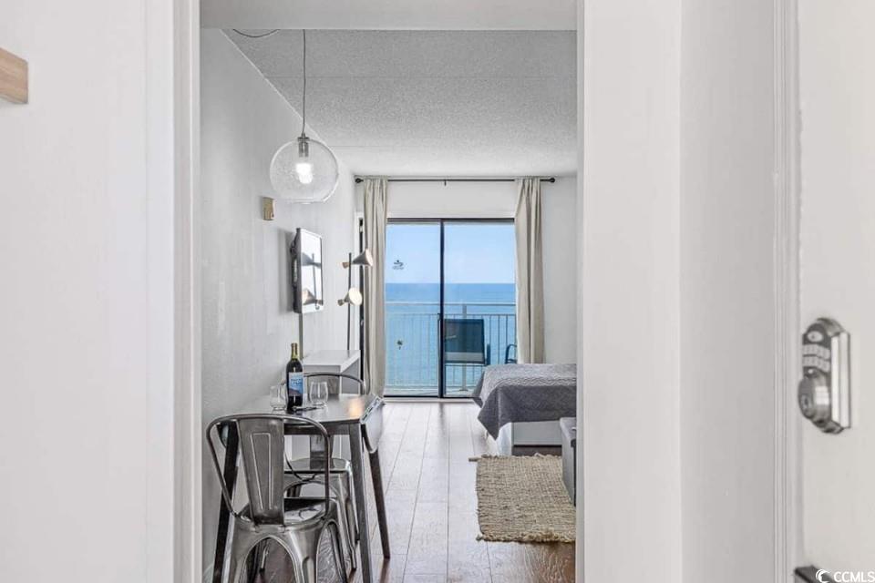 1207 South Ocean Boulevard, Unit 21001 Myrtle Beach, SC 29577 - Photo 9 of 23 Hallway with wood finished floors, a textured ceiling, and floor to ceiling windows