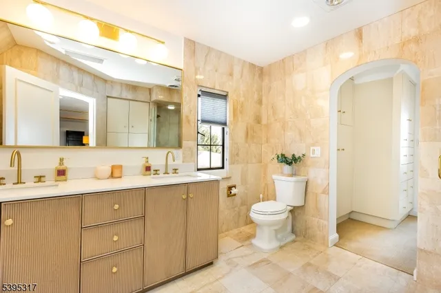 a bathroom with a double vanity sink toilet and a mirror