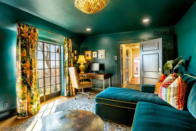 a living room with furniture a floor to ceiling window and a flat screen tv