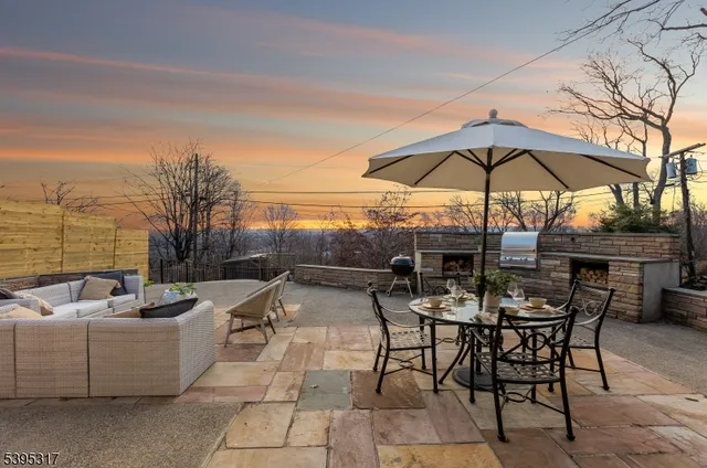 a view of a patio with a table and chairs under an umbrella
