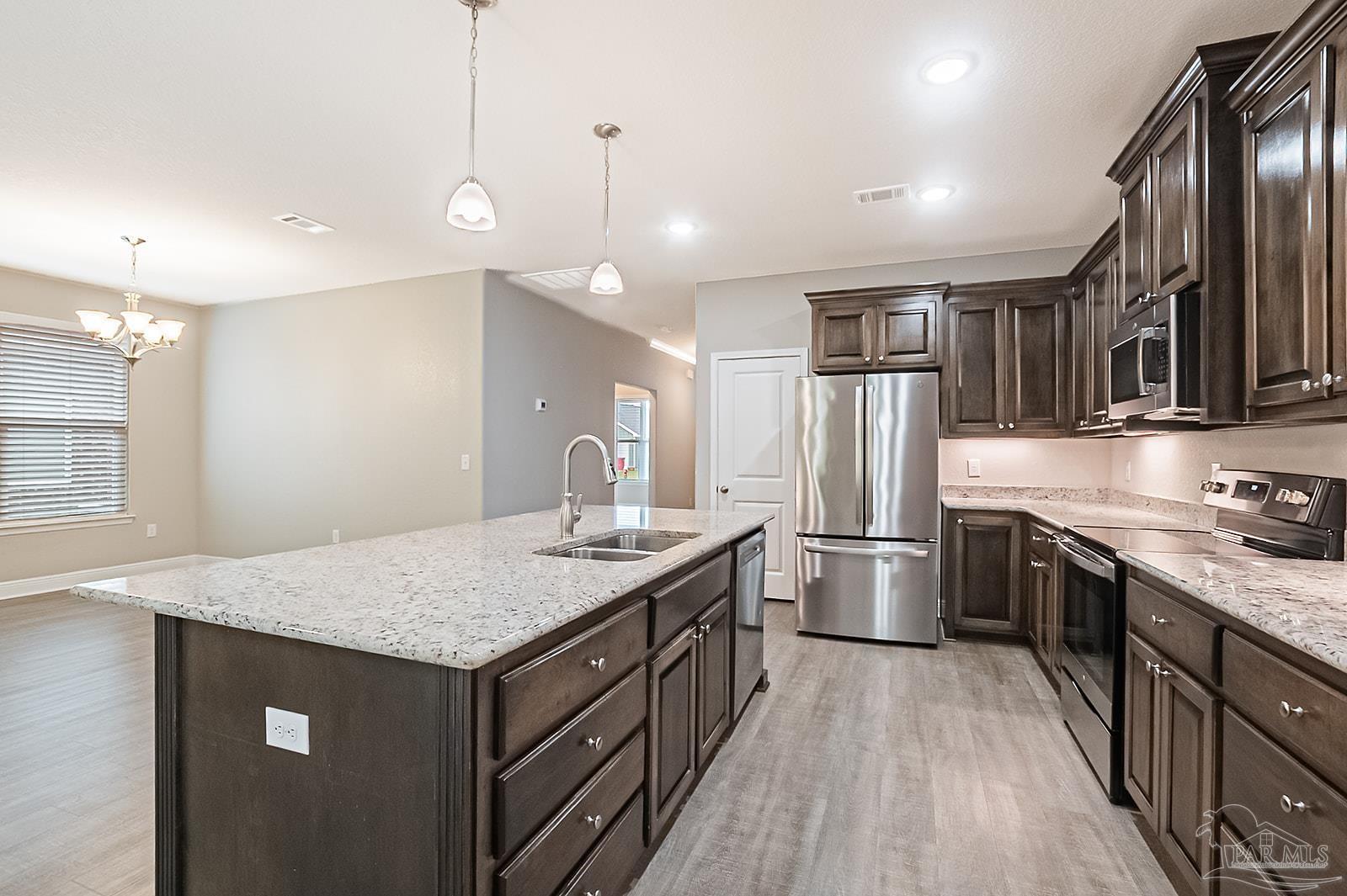 5398 Parkside Drive Pace, FL 32571 - Photo 26 of 36 a kitchen with stainless steel appliances granite countertop a sink stove and refrigerator