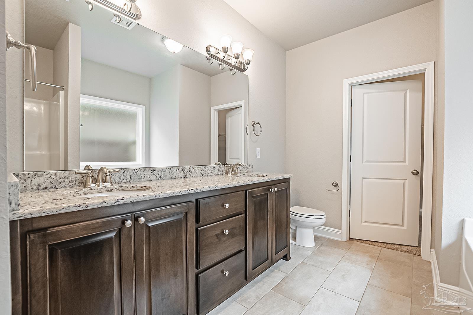 5398 Parkside Drive Pace, FL 32571 - Photo 32 of 36 a bathroom with a granite countertop sink a toilet and a mirror